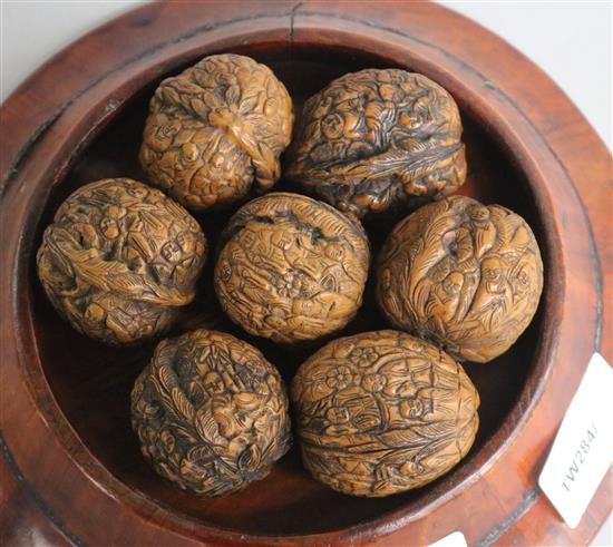 Seven Chinese carved walnuts, wood stand
